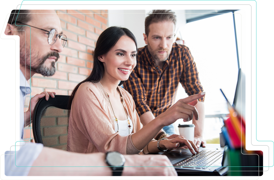 Photo of a woman pointing at a laptop screen while two male colleagues look on.