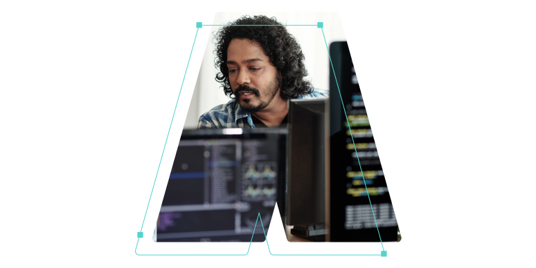A man behind some computer monitors outlined in the shape of the letter A.
