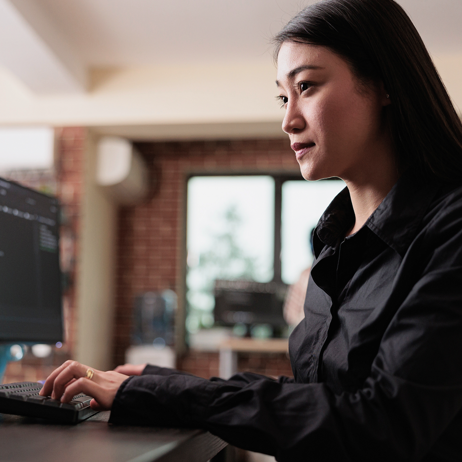A woman using a computer masked by expanded T A G 1 characters.
